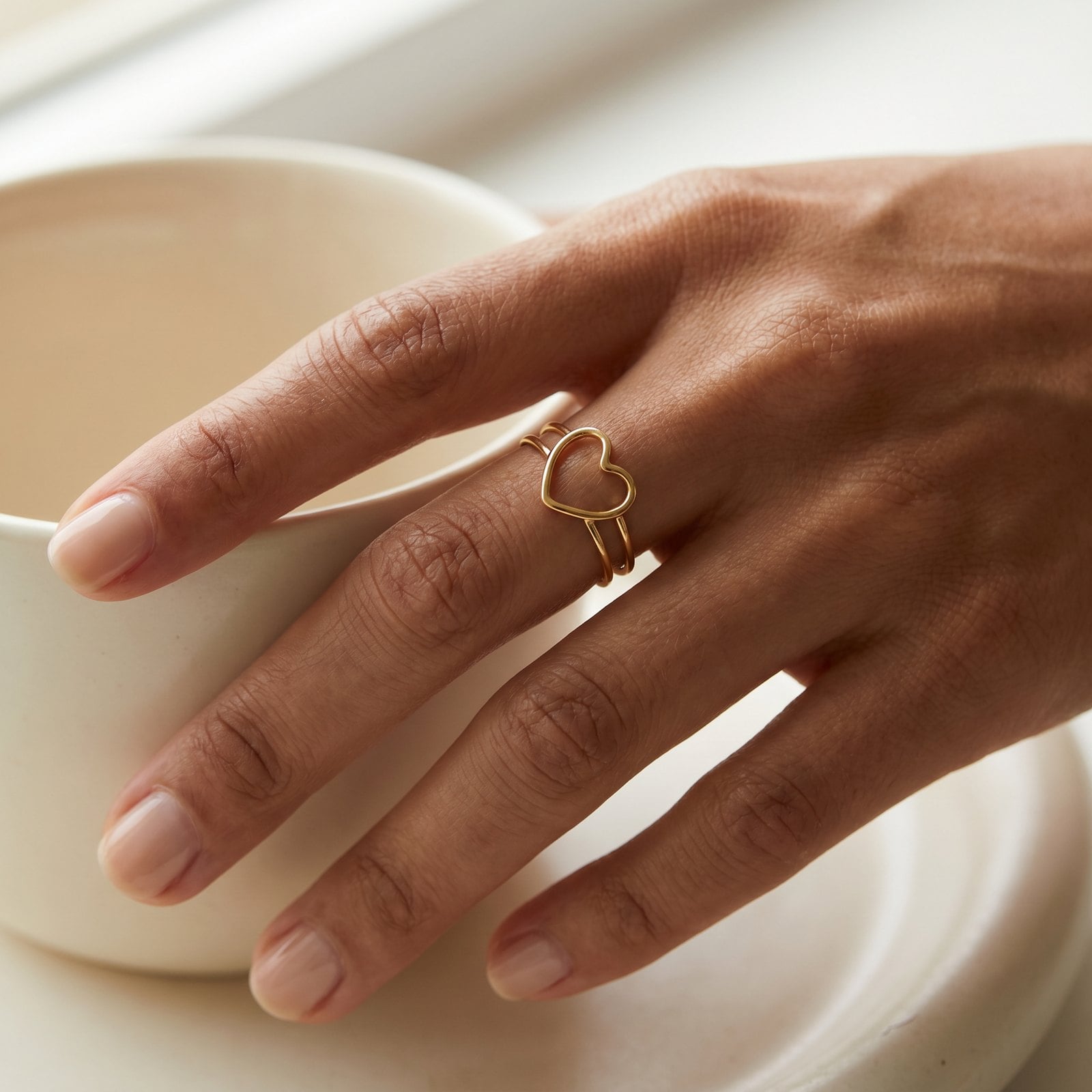Open-heart adjustable gold ring worn on the finger