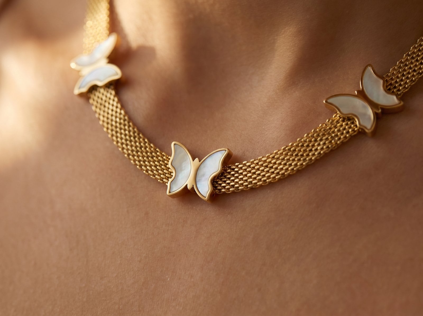 Macro of flat herringbone, box and figaro gold chains lying parallel and untangled on warm skin