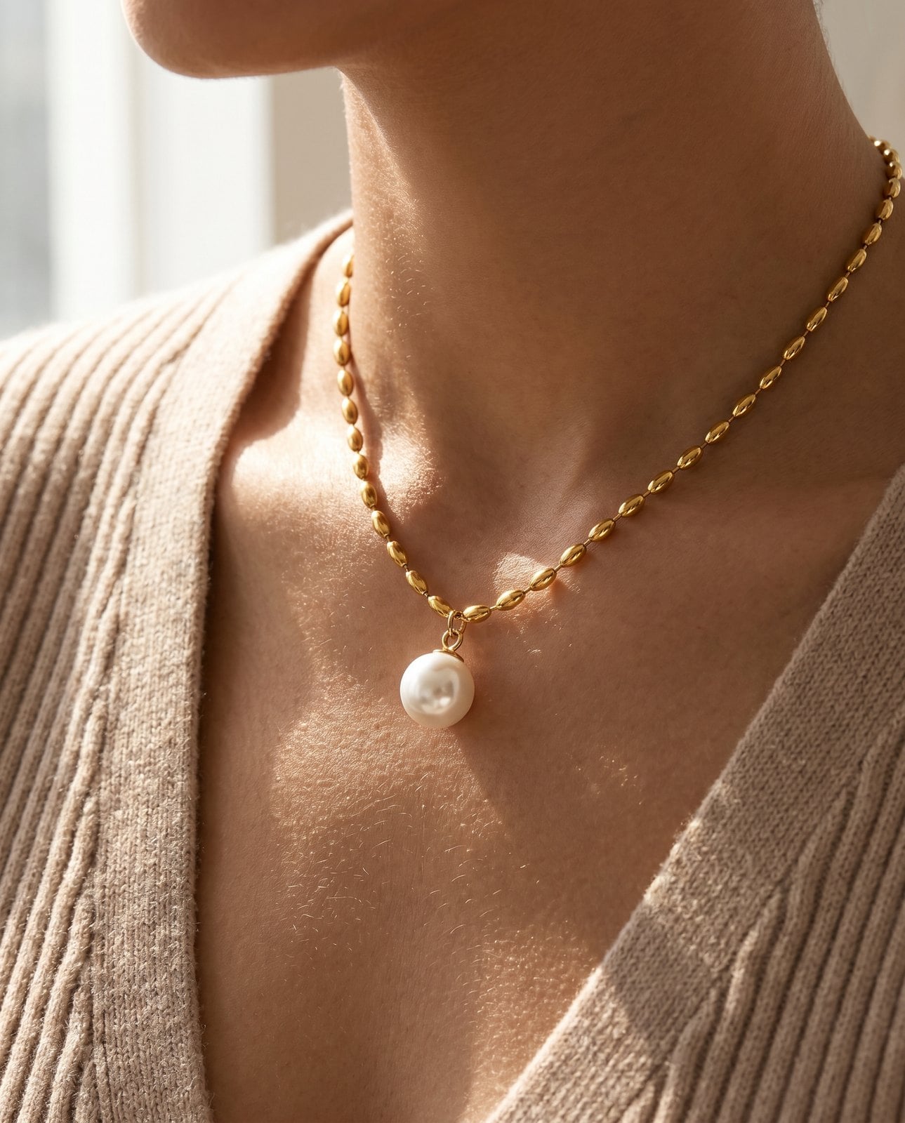 Dainty gold plated fine-chain necklace worn on a woman's collarbone in soft natural light