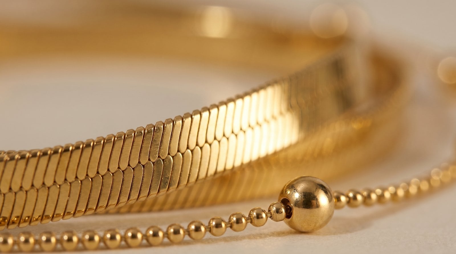 Extreme macro of 18K gold-plated chain links showing the smooth warm yellow-gold electroplated surface