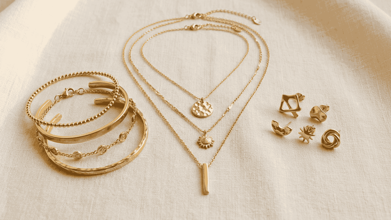 Layered gold plated chain necklaces and stacked adjustable rings showing current Canadian minimalist jewelry trends